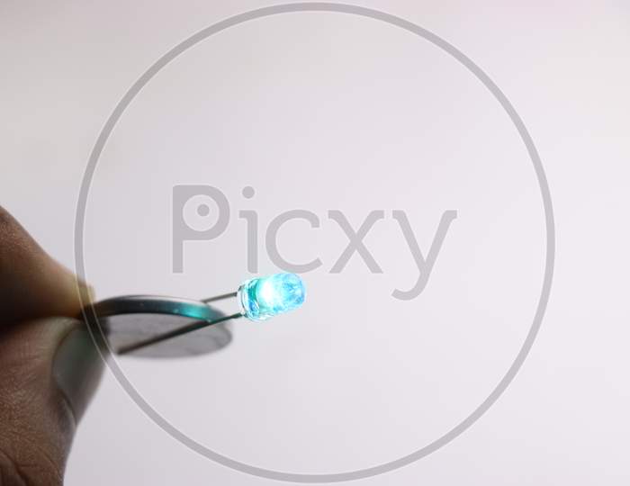 Coin Battery Is Used To Glow The Blue Led On White Background