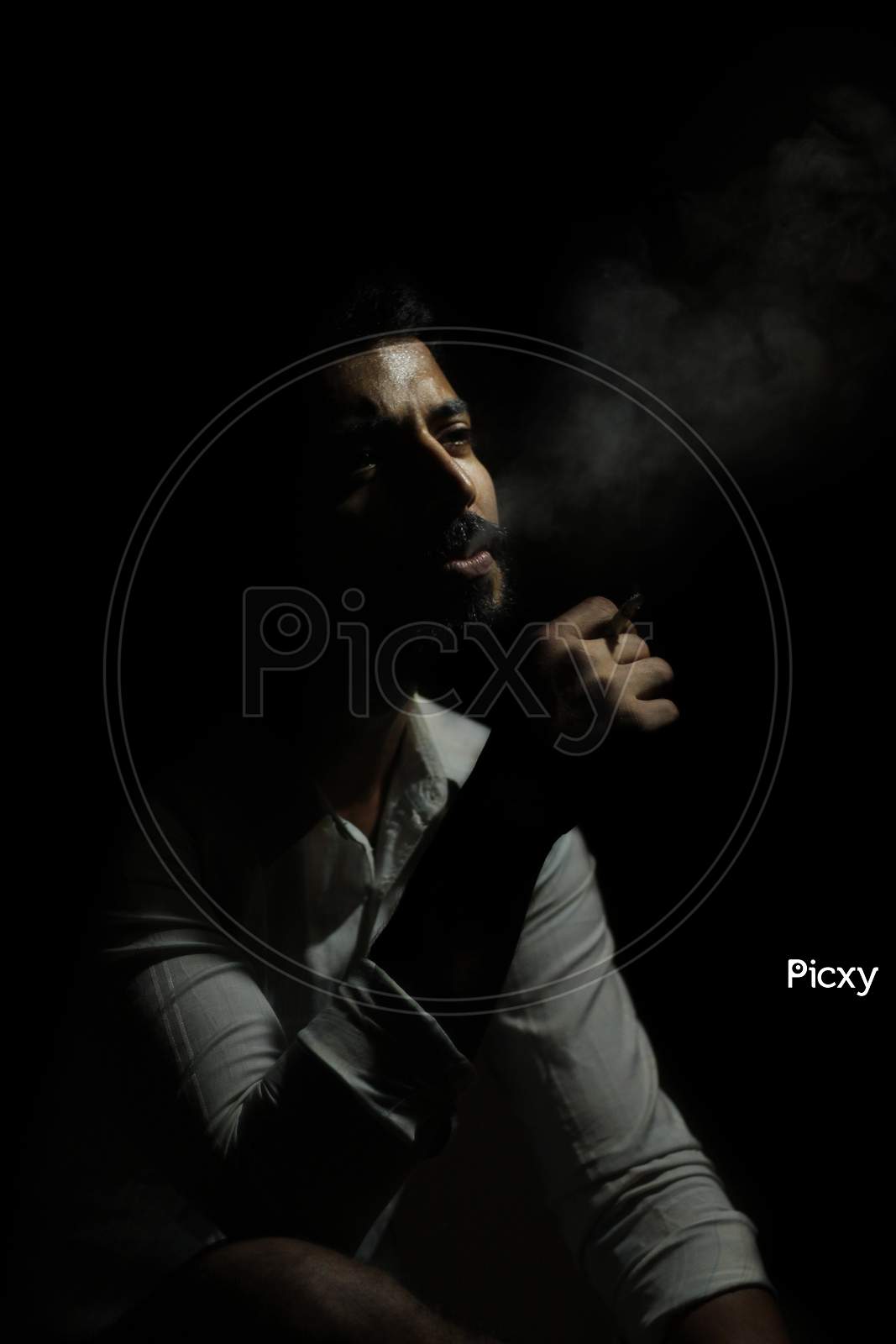 May 2020, A handsome guy smoking cigarette in a dark room.
