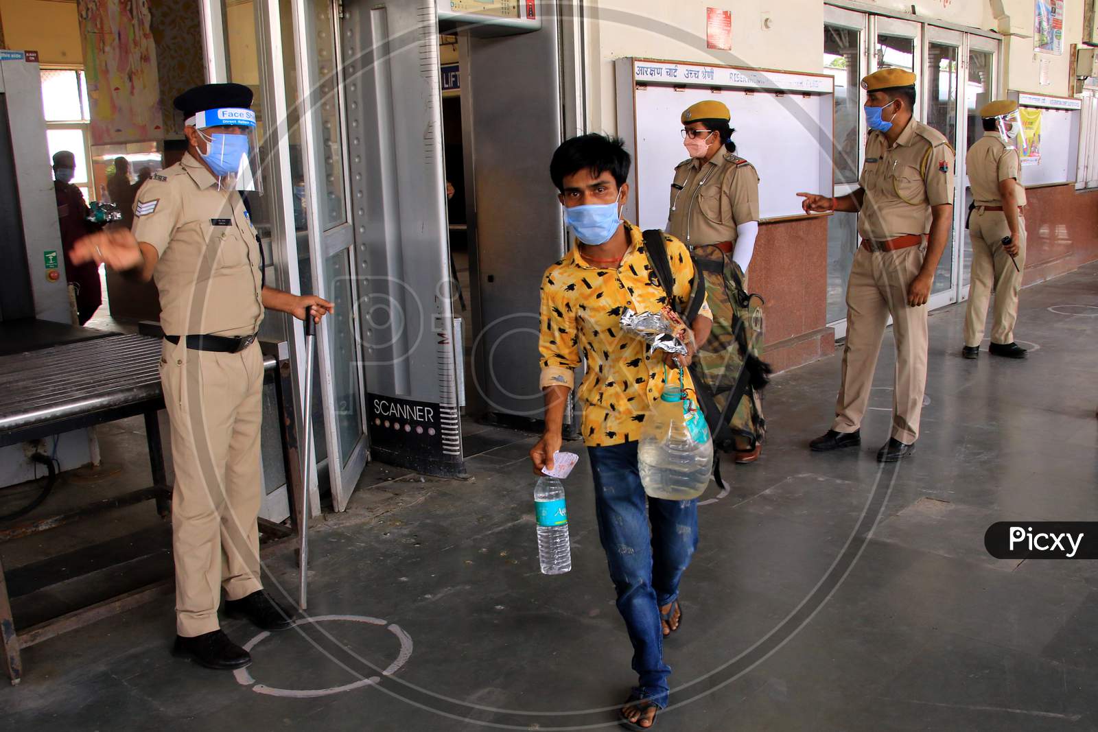 Security personnel check migrants near a special train which will be on-boarded by migrants to Bihar State from Ajmer railway station during a government-imposed nationwide lockdown as a preventive measure against the COVID-19 or coronavirus, in Ajmer on May 10, 2020.
