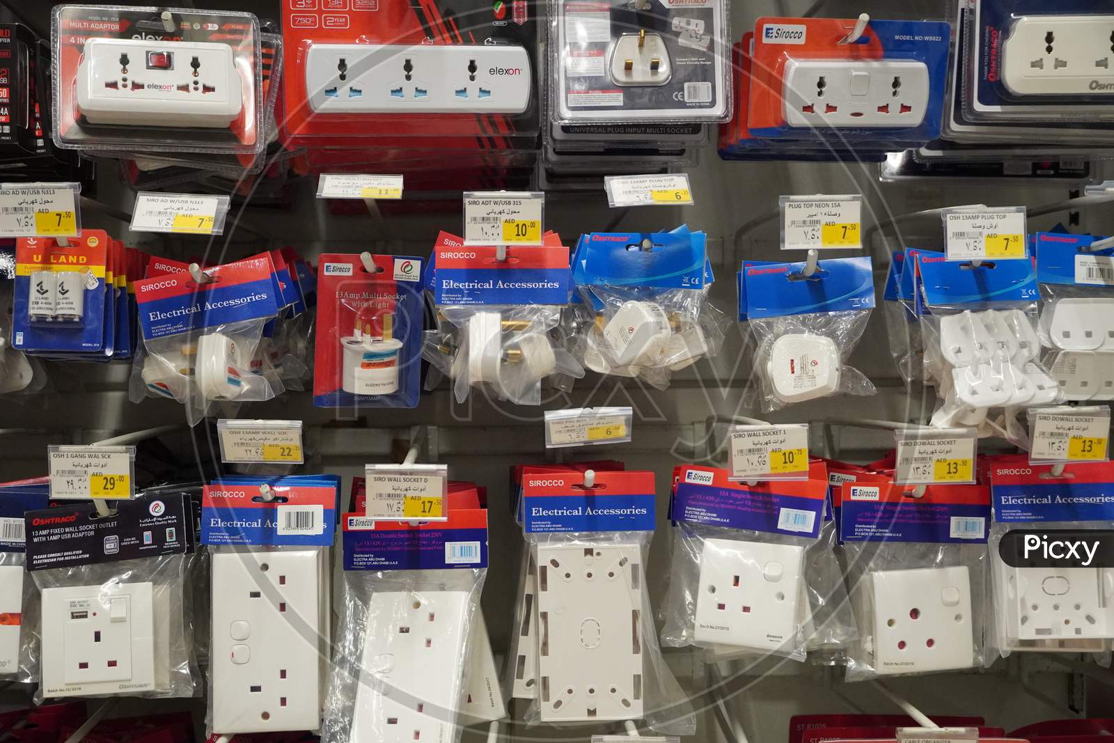Selection Of Extension 3 Pin Plug Socket Wire On Supermarket. Many Adapter Power Plug Or Extension Cord Hang On The Shelf. Packed Ready Different Kinds Of Power Strips.