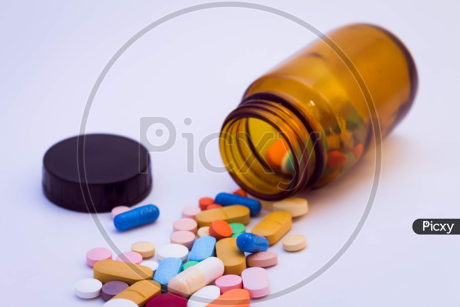Brown Glass Bottle With Pills Of Various Colors. Drugs For Use In Humans. Pills On White Background.