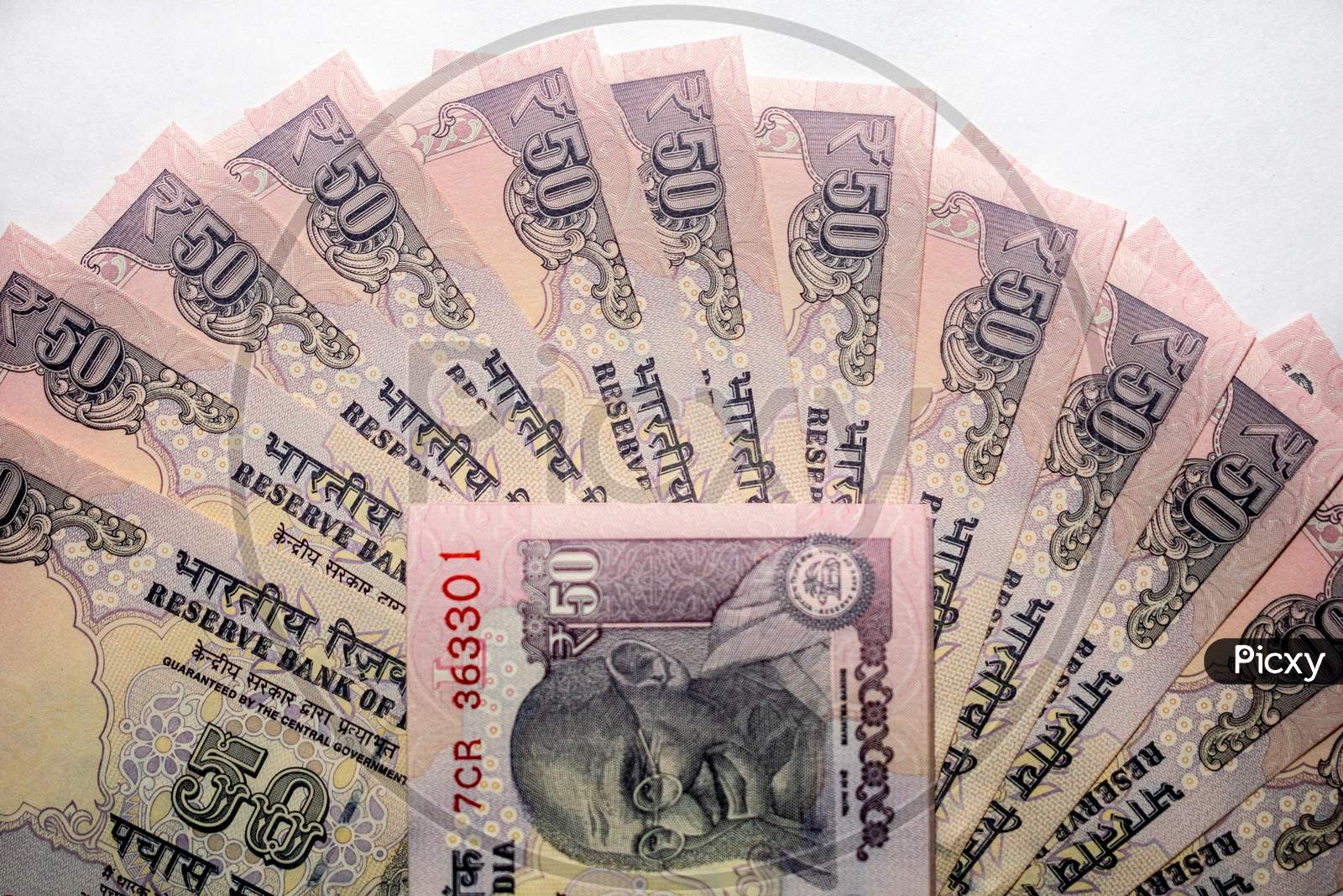 A bundle of 50 rupees notes put on the Indian currency 50 rupees notes on a white background