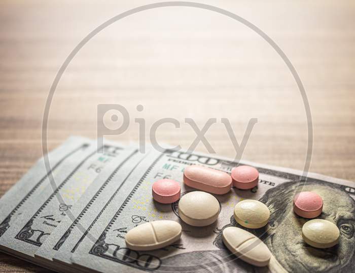 Concept Of Cost Of Medicines. Pills On A Brown Table With Bills.