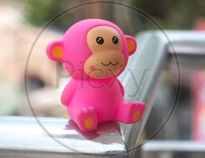 Pink monkey toy on metal grill