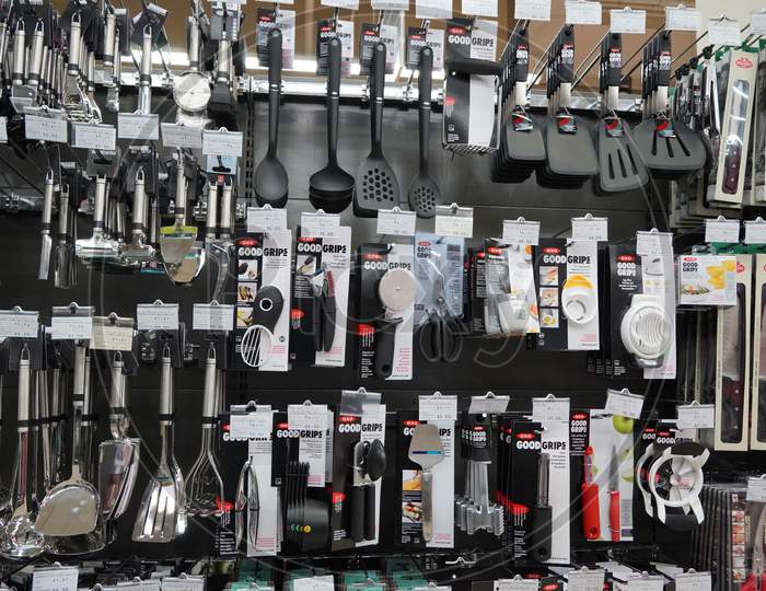 Kitchen Tools Hanging In Shop. Large Set And Variety Of Different Manufacturers On Shelves In Store. Kitchenware, Knives, Spatulas, Ladle, Tongs, Spoons, Silicon Tools.