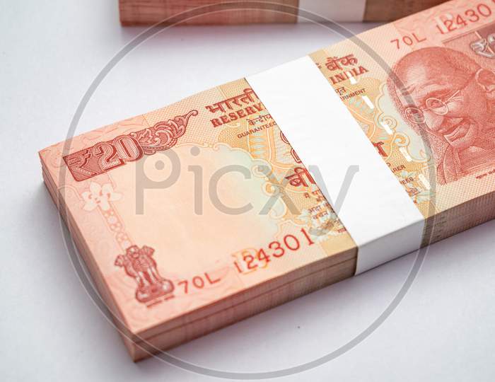 Bundles of Indian currency notes of 20 rupees isolated on white background