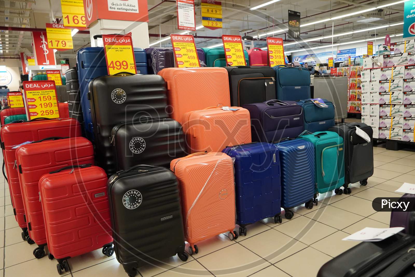 Department Store Interior View With Luggage Zone. Multicolored Suitcases In Store For Sale. Plastic And Cloth Suitcases With Discount Tags. Concept Of Black Friday Discounts.