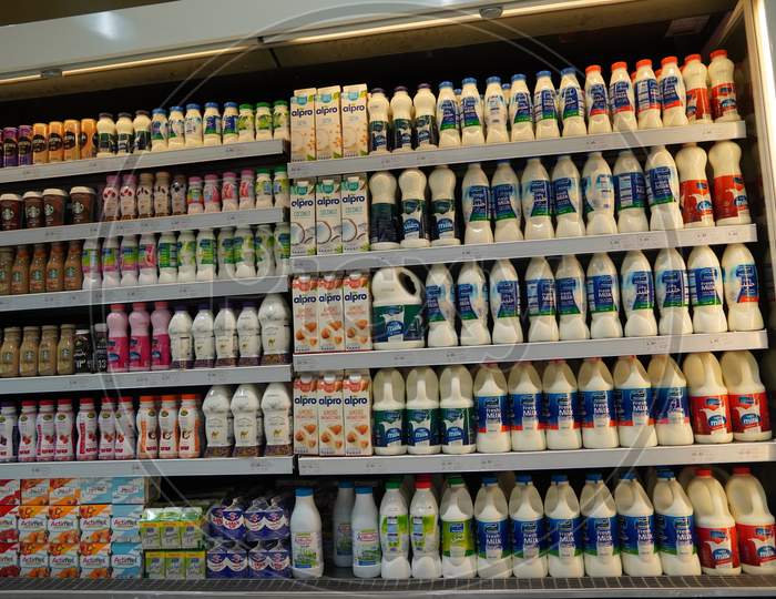 Milk Bottles Arranged On Shelves For Sale. Variety Of Sizes. Also Present Flavored Milk Strawberry Milk, Camel Milk, Coconut Milk, Almond Milk. Almarai Brand Milk Bottles.