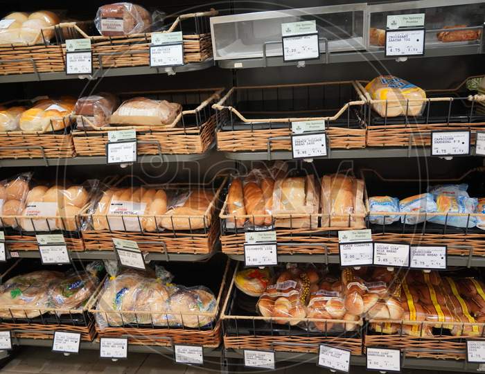 Different Fresh Bread On The Shelves In Bakery. Interior Of A Modern Grocery Store Showcasing The Bread Aisle With A Variety Of Prepackaged Breads Available.