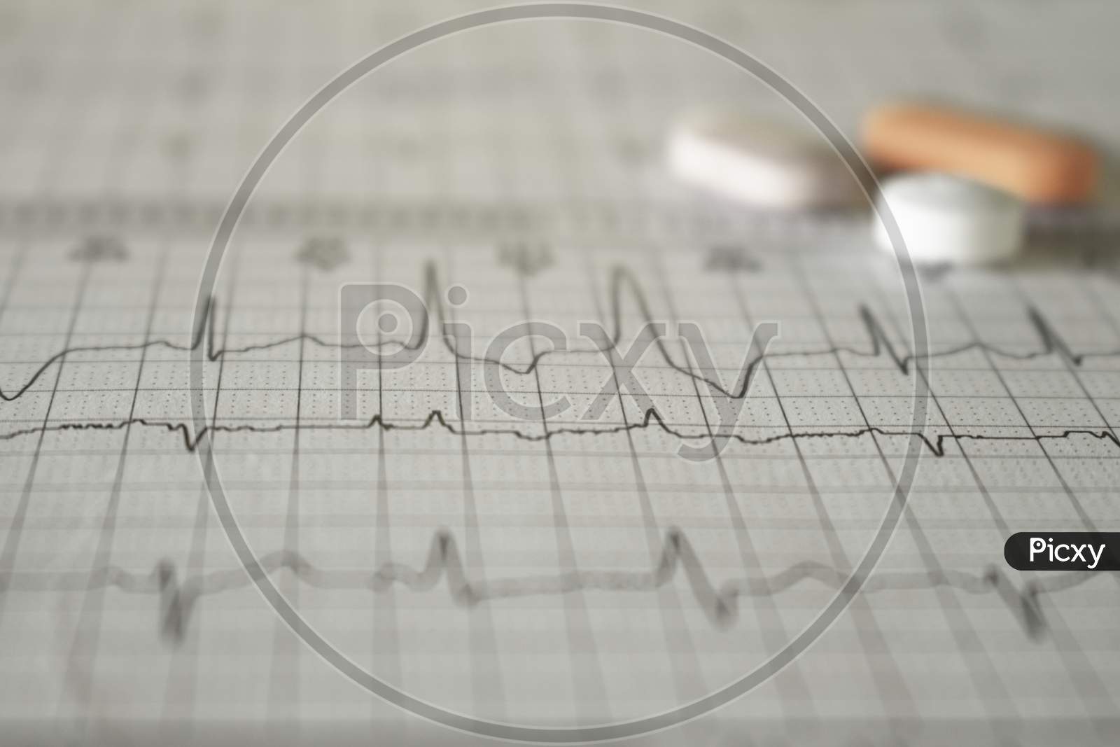 Heartbeat Represented On Paper. Electrocardiogram With Selective Focus. Pills Without Focus On Paper.