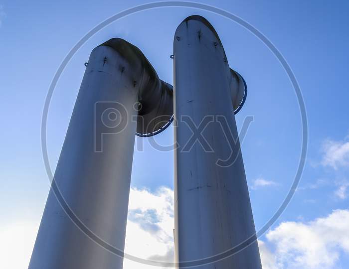 Industrial pipes made of steel in front of a blue sky