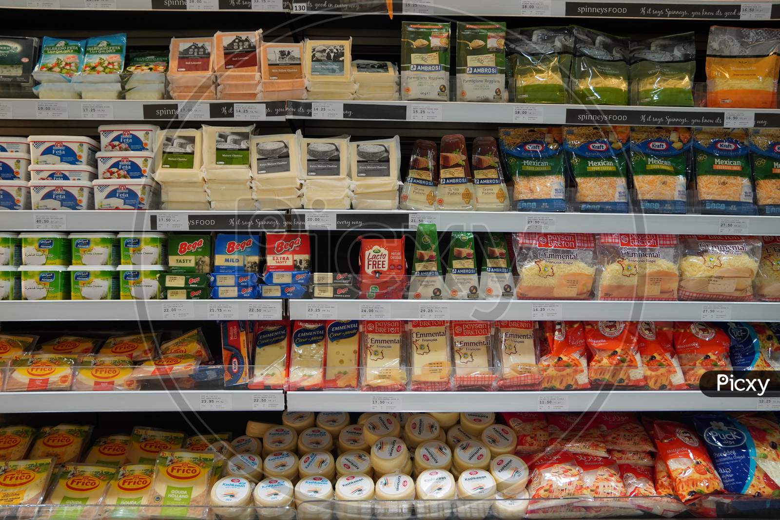 Different Types Of Cheese On Shelves In A Grocery Store. Shelf Of Packaged Products, Butter And Cheese At A Market. Cheddar, Edam, Mozzarella, Gouda, Blue Cheese.