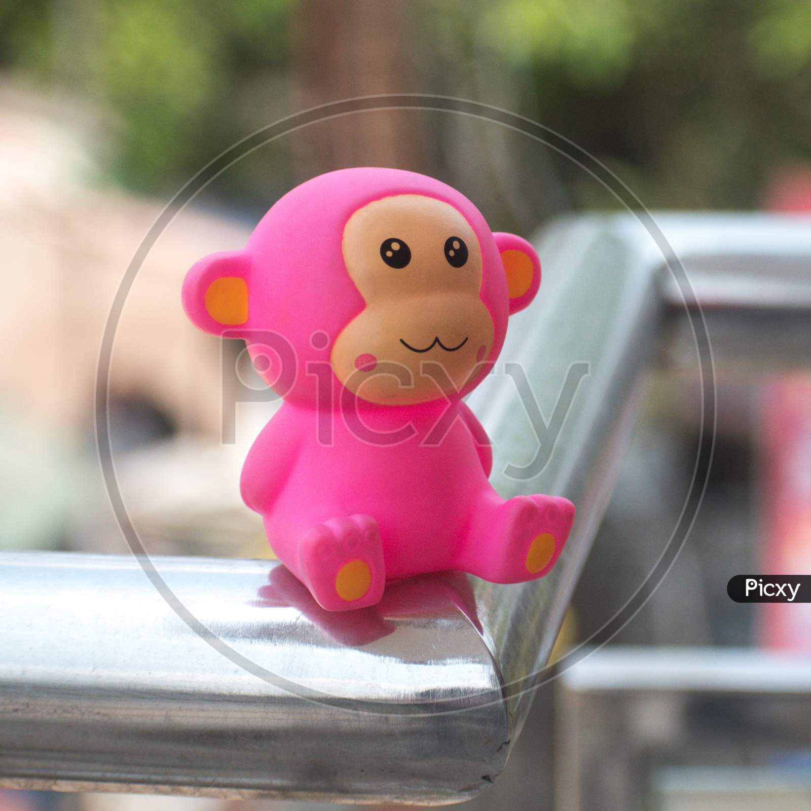 Pink monkey toy on metal grill