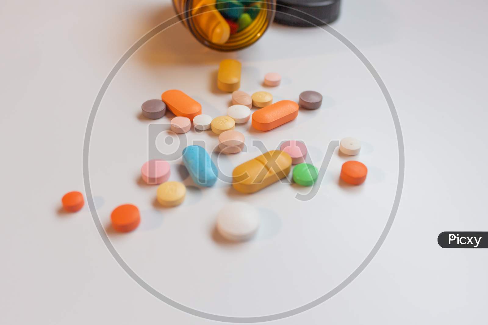 Medications In The Form Of Pills And Capsules On A White Background. Brown Glass Vessel.