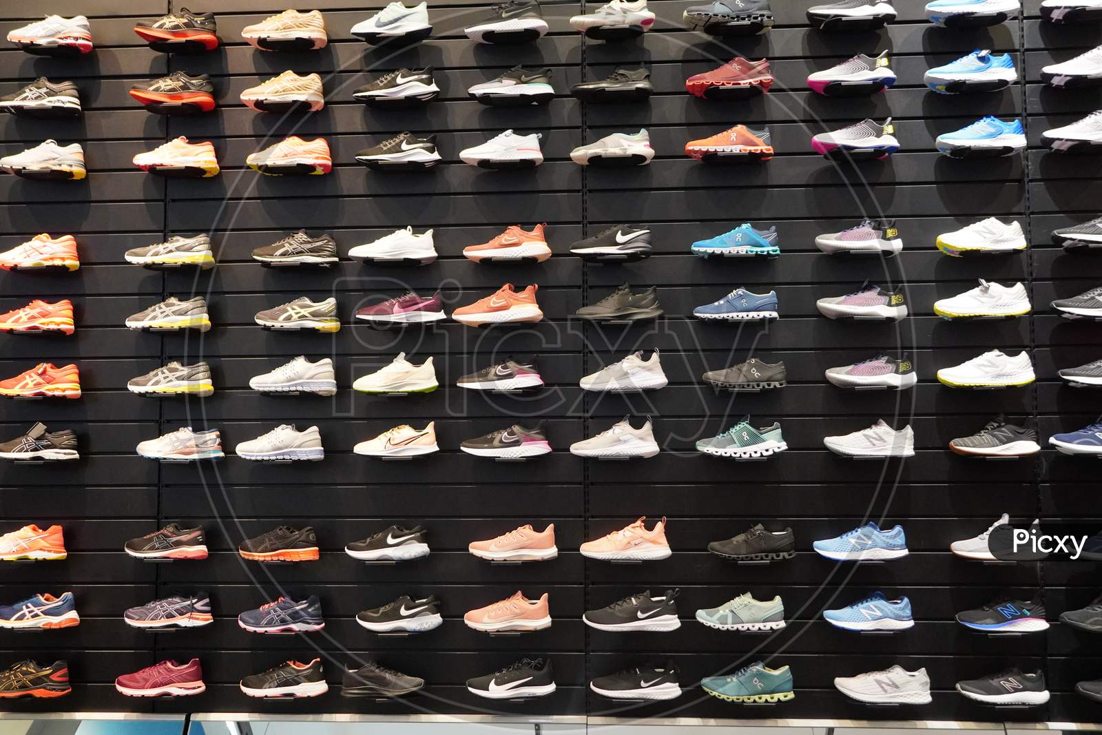 Image of Shop Display Of A Lot Of Sports Shoes On A Wall. A View Of A