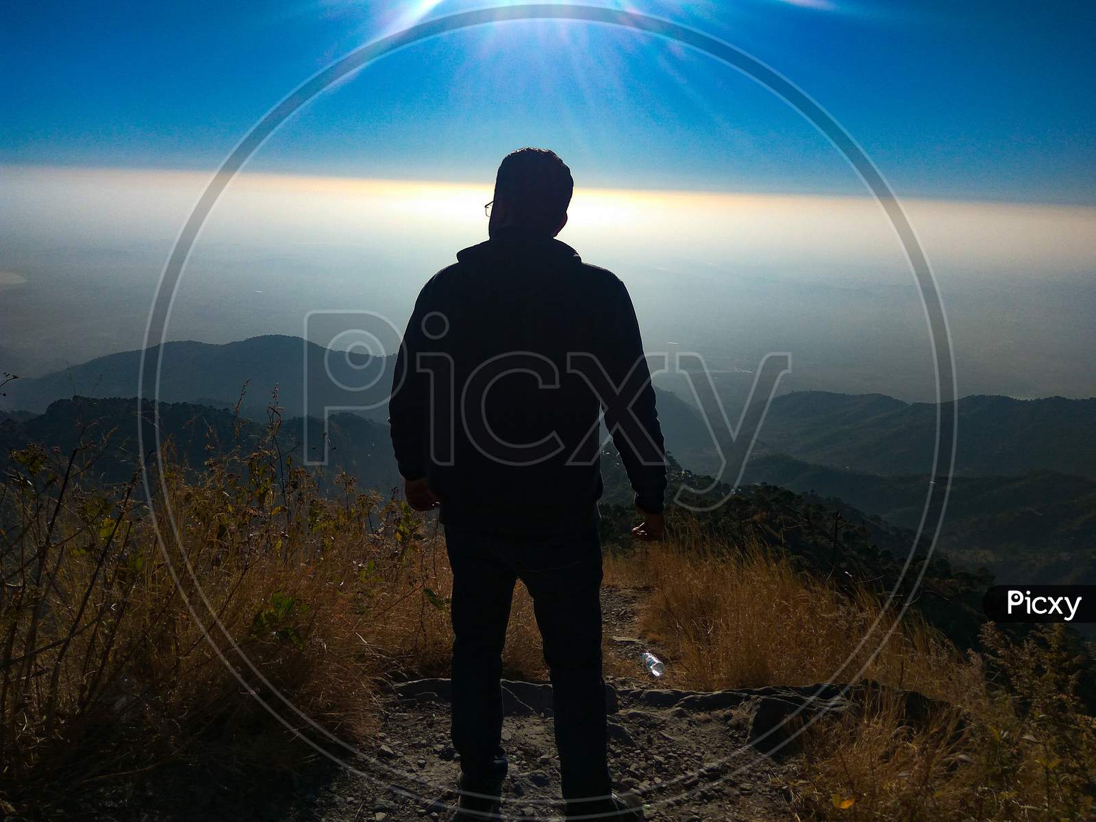 Traveler standing at cliff in Kasauli hills of himachal pradesh under clear sunlight landscape