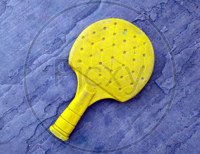 Equipment for table tennis - yellow plastic racket isolated on stone background