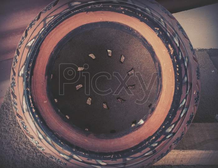 A Close Up Shot Of Decorated Pot Having Circular Pattern Inside.