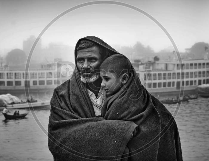 Bangladesh – January 06, 2014: A Boy And His Father Watching The Winter River With The Full Body Of Wearing A Thick Blanket On A Winter Morning.