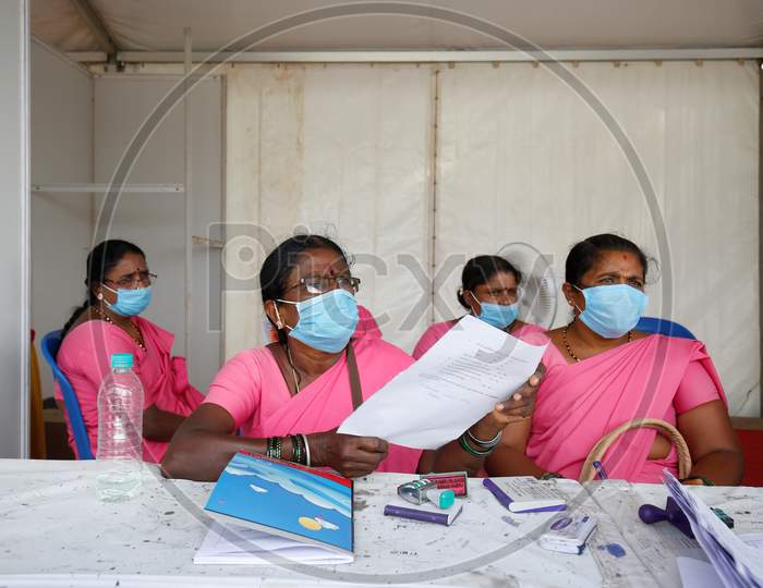 Accredited Social Health Activists (ASHA) workers check paperwork of passengers at a police check post during the nationwide lockdown to stop the spread of coronavirus (Covid-19) in Bangalore, India.