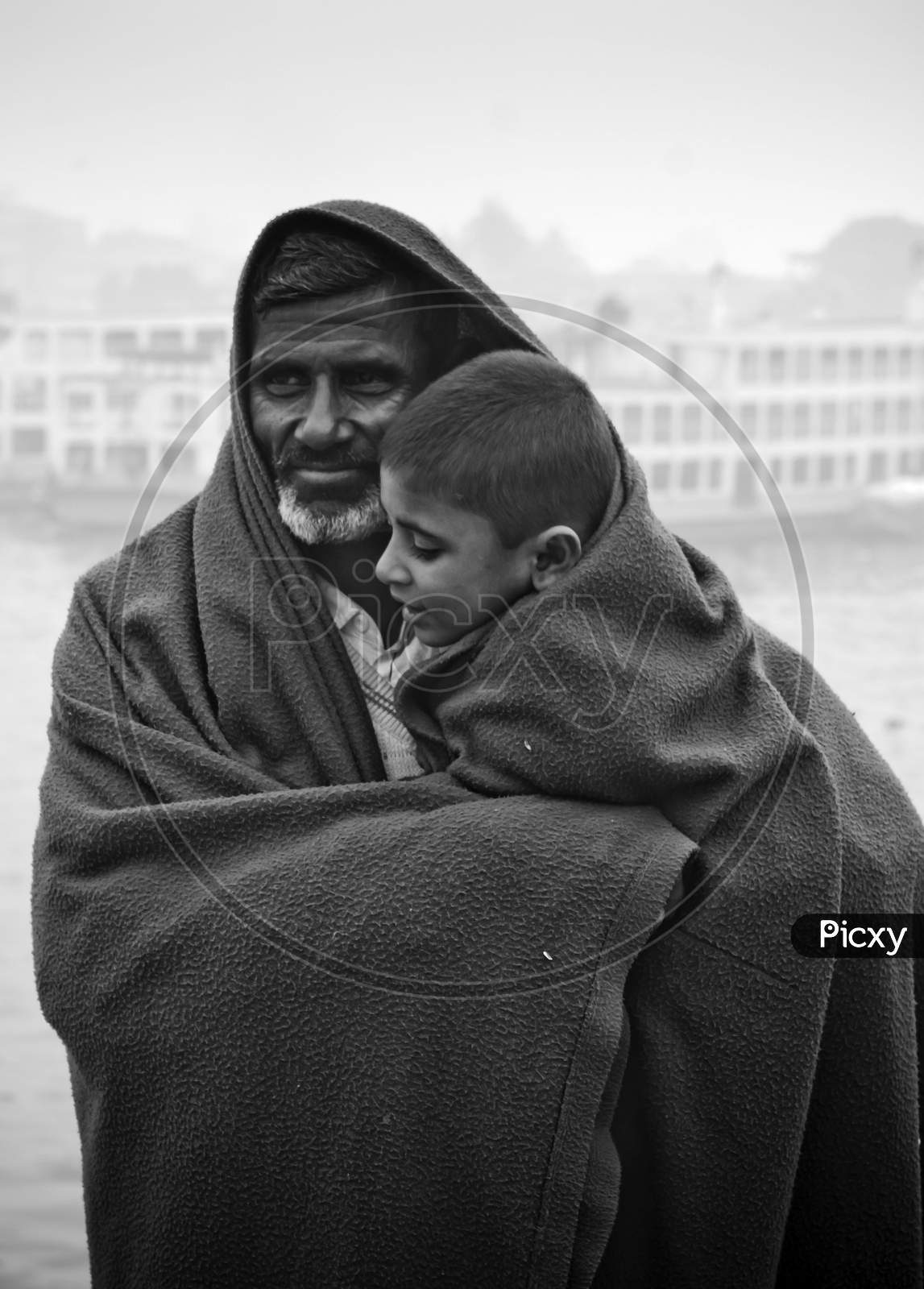Bangladesh – January 06, 2014: A Boy And His Father Watching The Winter River With The Full Body Of Wearing A Thick Blanket On A Winter Morning.