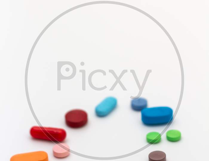 Pills Of Colors On A Neutral White Background. Medications Forming A Circle. Legal Drugs From The Pharmaceutical Industry.