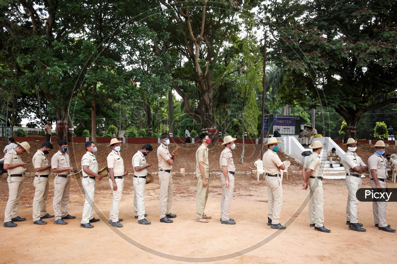 Police personnel stand in a queue to check for covid-19 during a health screening camp for the police forces in Bangalore, India.
