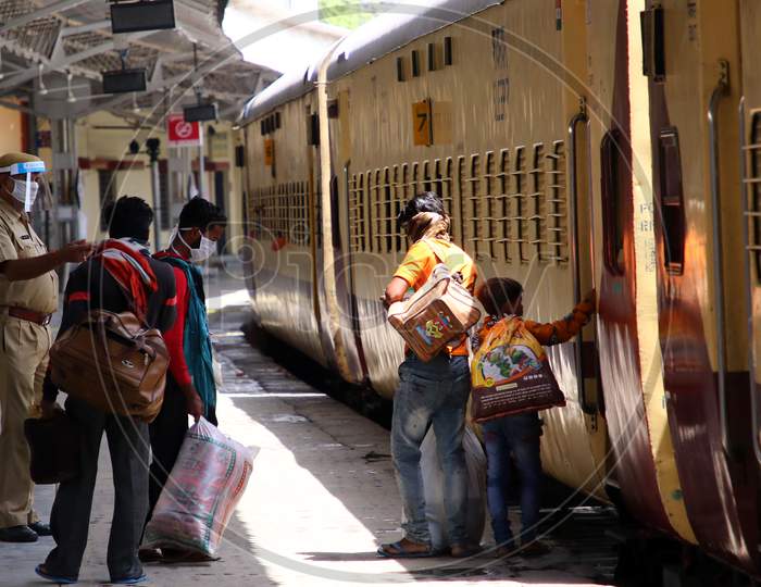 A Security Personnel Checks Migrants Near A Special Train Which Will Be On-Boarded By Migrants To Bihar State From Ajmer Railway Station During A Government-Imposed Nationwide Lockdown As A Preventive Measure Against The Covid-19 Or Coronavirus , In Ajmer on May 13, 2020.
