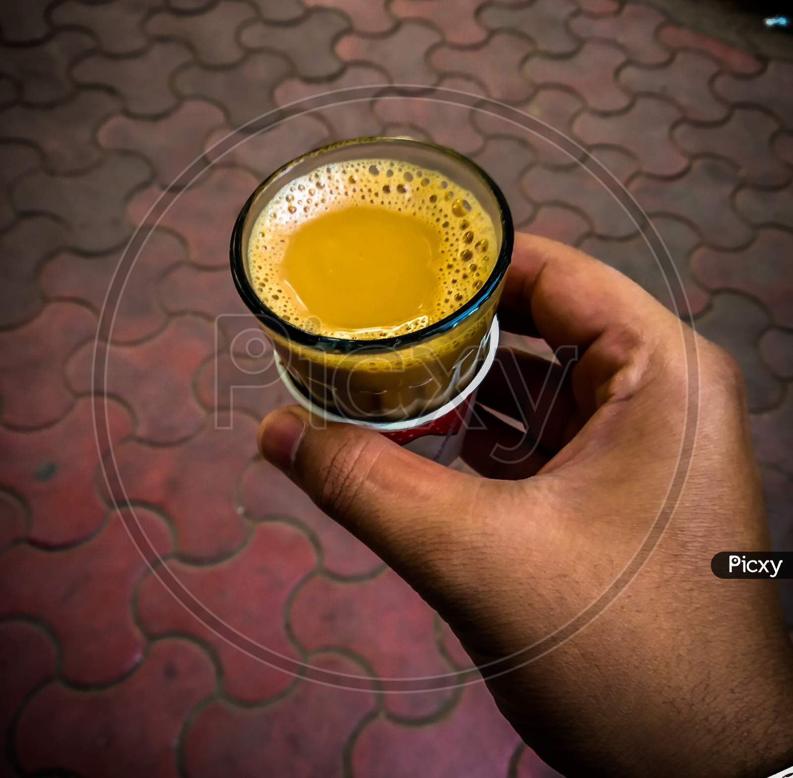 A Close Up Shot Of Hand Holding Glass Of Tea ( Chai )