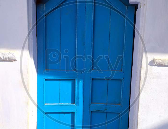 a blue color wooden door on white wall