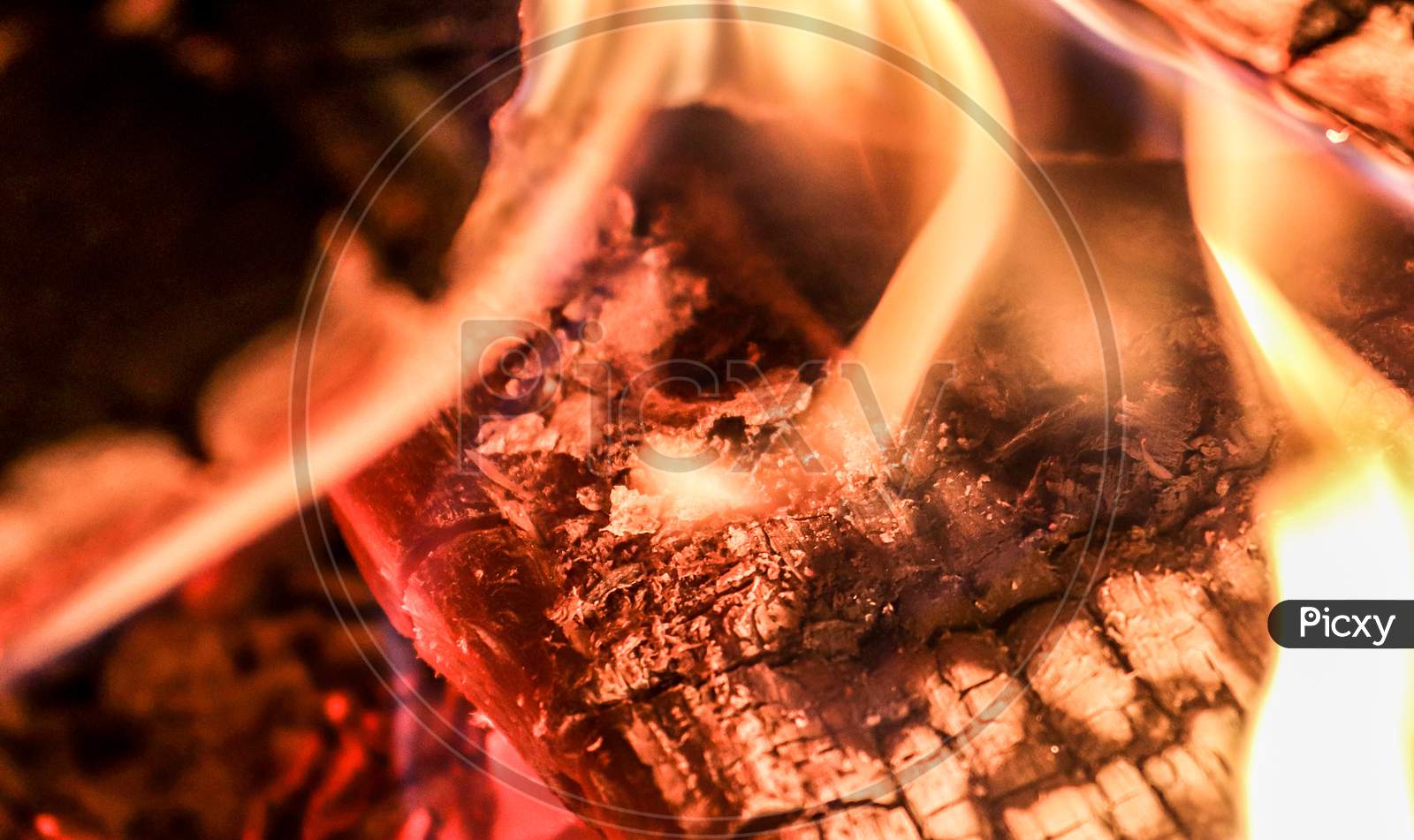 Close up of a hot burning fireplace with flames and glowing ember