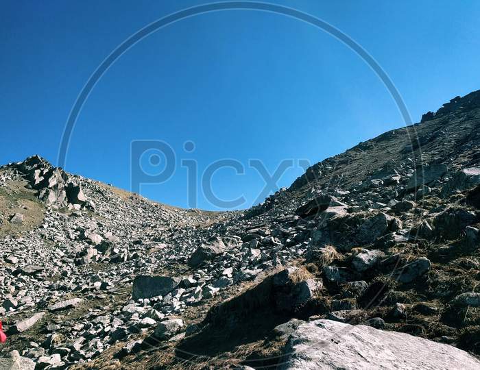 Rocks With Shadow On The Top Of The Mountain With Blue Sky At Background.