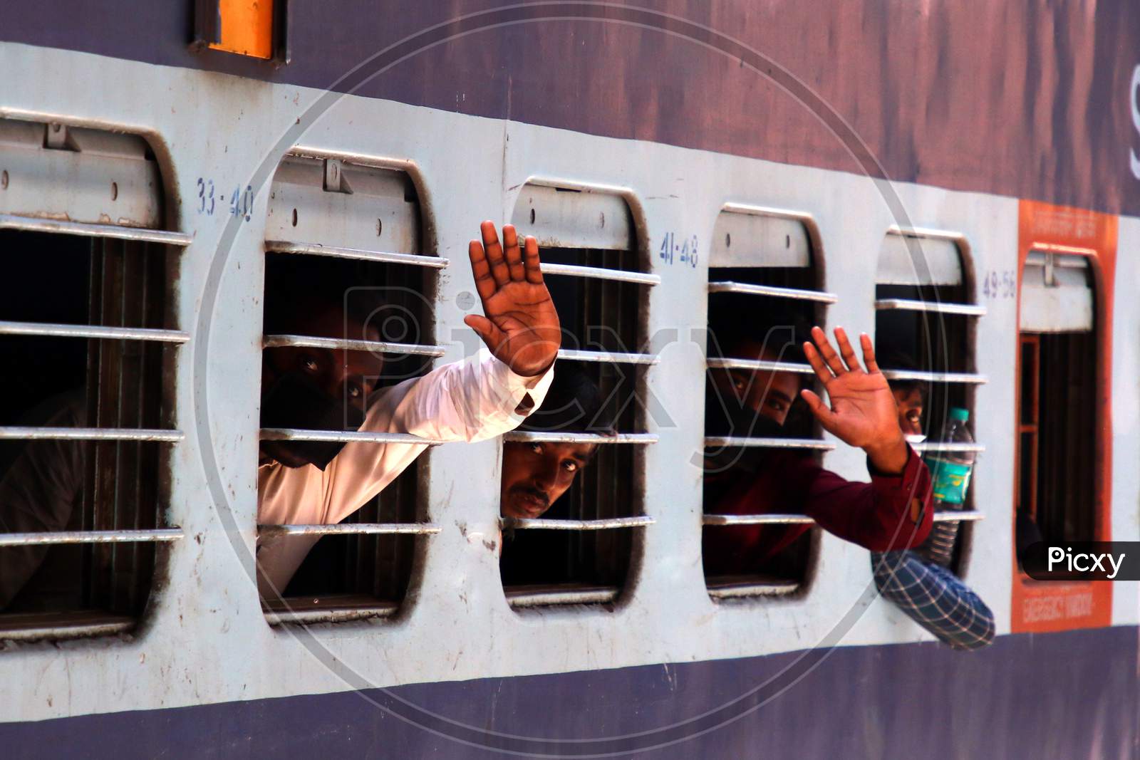 Stranded migrants wave as they board a special train to Bihar State from Ajmer railway station during a government-imposed nationwide lockdown as a preventive measure against the COVID-19 coronavirus, in Ajmer on May 13, 2020.