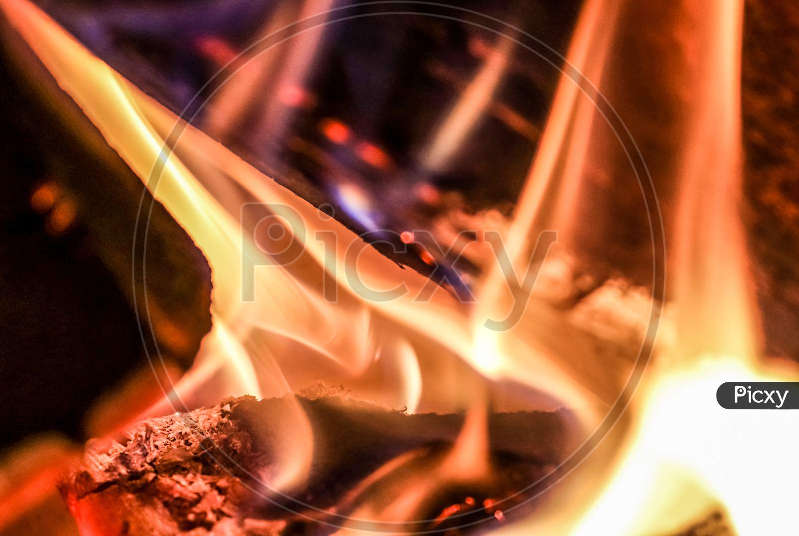 Close up of a hot burning fireplace with flames and glowing ember