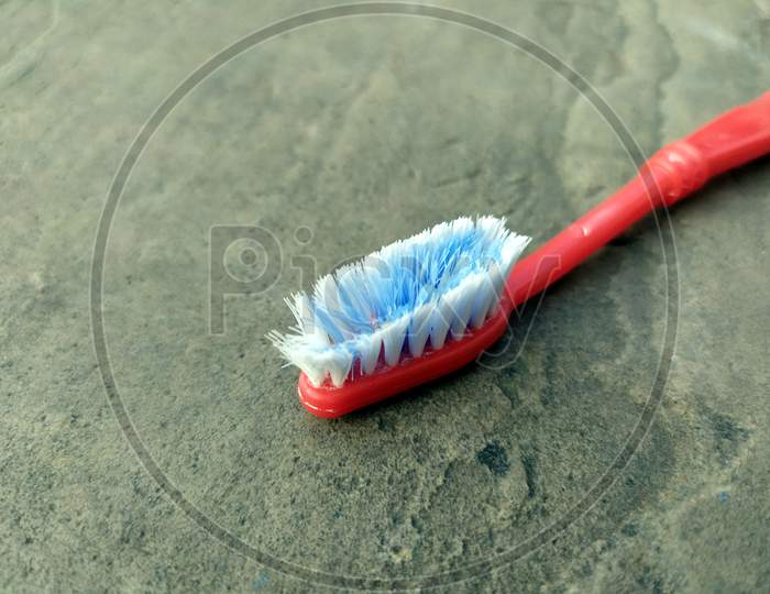 red color toothbrush isolated on a stone  background