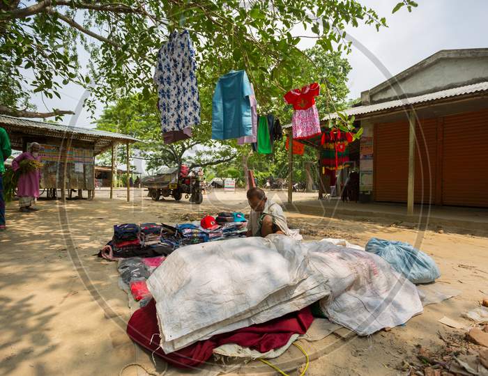 Bangladesh - May 19, 2019: A Rural Village Businessman Selling Cloth And Products To Hang Up On The Tree Trunk, Meherpur, Bangladesh.