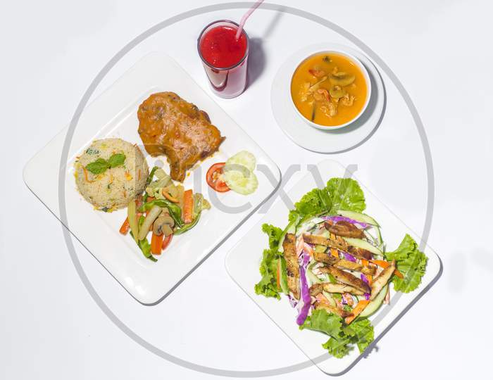 Asian Style Ramadan Sehri Food Set. Healthy Full Course Meal. A Plate Of Grill Chicken Salad, A Plate Of Plane Rice And Chicken Stake And Saute Vegetable And Thai Soup With A Glass Of Watermelon Juice On White Background.