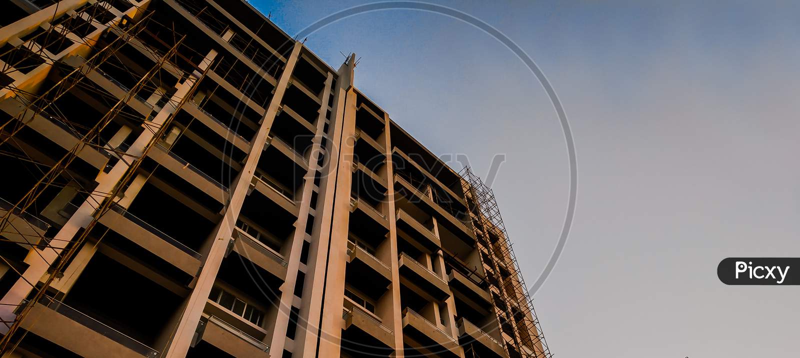 A Building Which Is Under Construction With Blue Sky Shoot From Bottom Angle. Can Be Used As A Background.