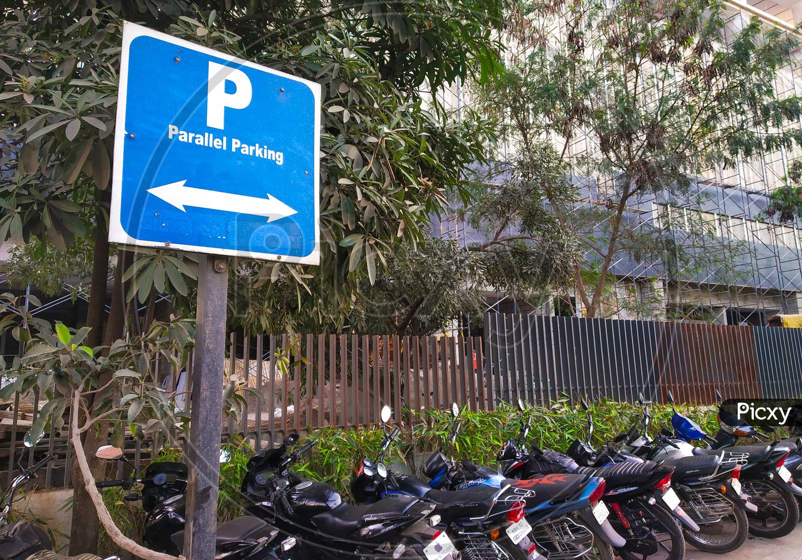 Parallel Parking Sign Board With Parallel Parked Two Wheelers In Front Of Corporate Office In Urban Area