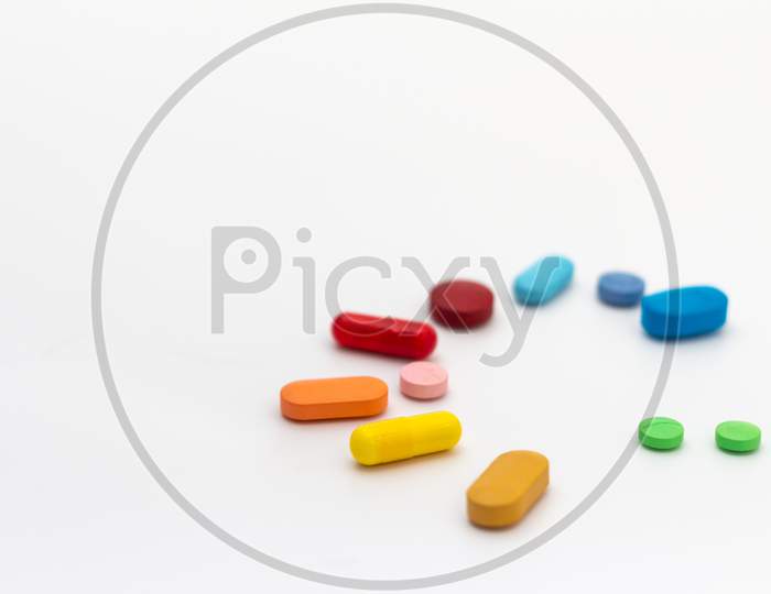 Pills Of Colors On A Neutral White Background. Medications Forming A Circle. Legal Drugs From The Pharmaceutical Industry.