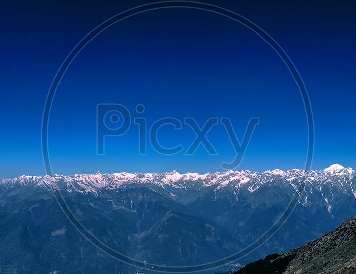 Himalaya A Snow Caped Mountain Range With Blue Sky.