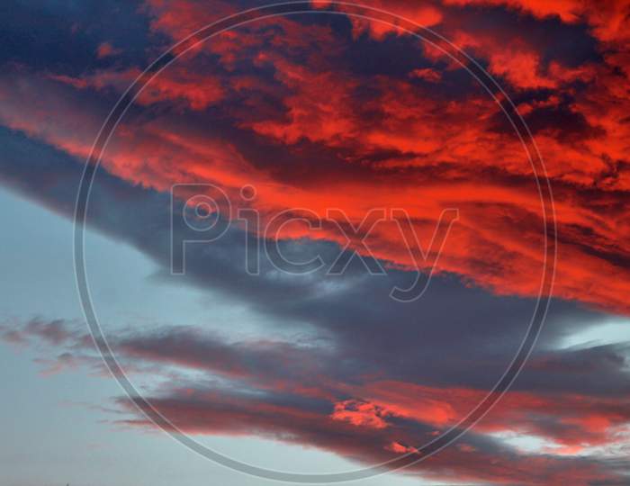 Beautiful red and orange cloud formations at sunrise in a panoramic sky view