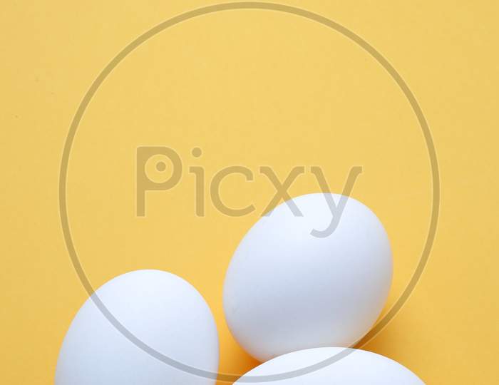Eggs,Three White Egg On The Yellow Background In Center,Copy Space For The Ads