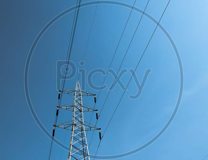 Isolated Electrical Tower In The Blue Sky With Electrical Wires