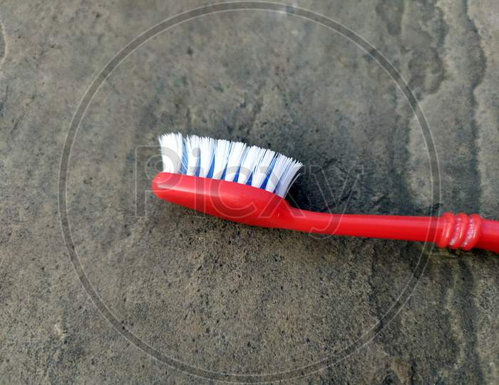 red color toothbrush isolated on a stone  background