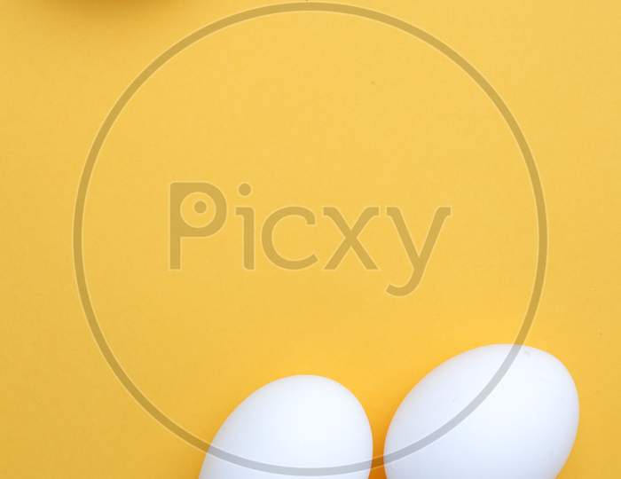 White Egg On The Yellow Background In Center,Copy Space For The Ads
