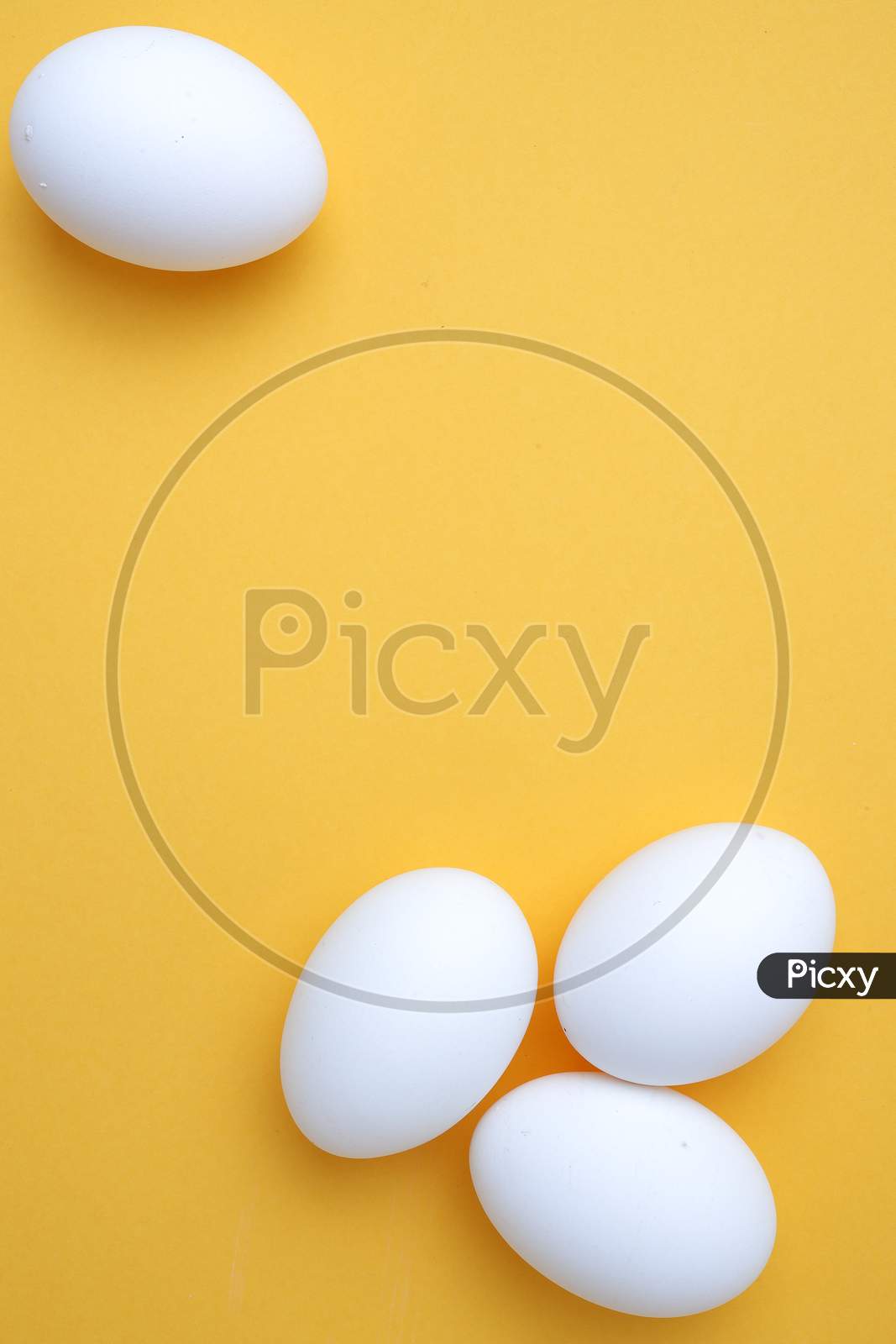 White Egg On The Yellow Background In Center,Copy Space For The Ads