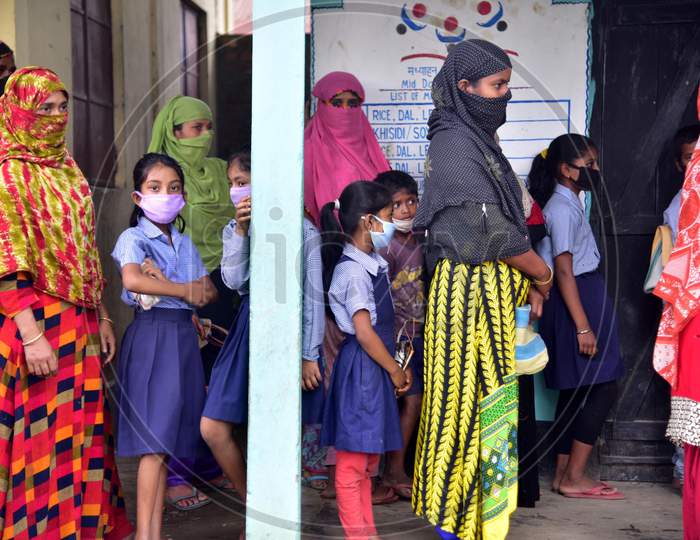 School Children Stand And Their Families Stand In Queue For Free Rice And Money To Be Given By The Volunteers During Nationwide Lockdown Amidst Coronavirus Or COVID-19 Pandemic in Nagaon on May 14 2020