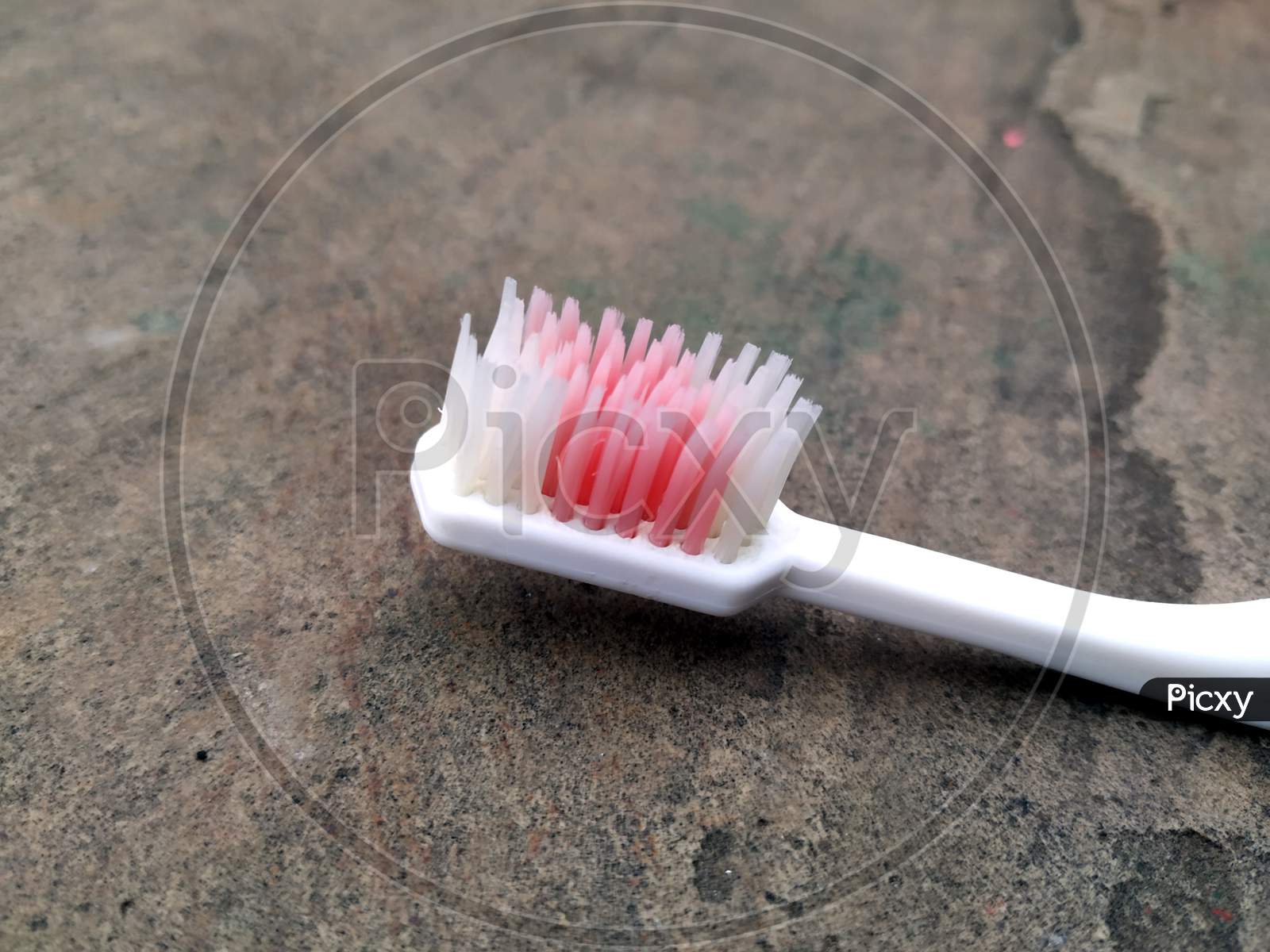 a white tooth brush put on a stone background