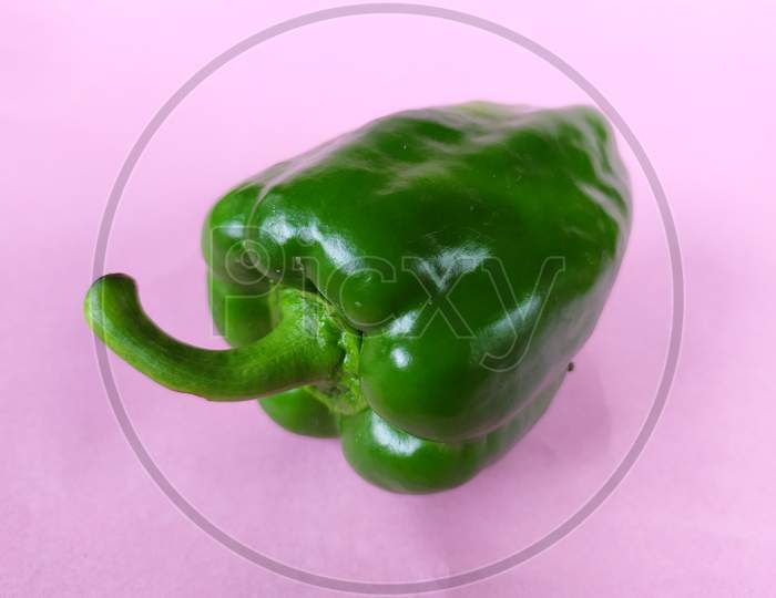 Green capsicum on pink background.